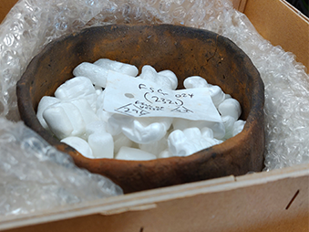 small iron age pot packed in archive box