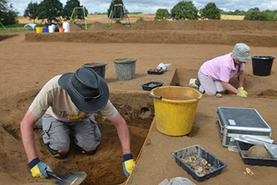 two people in field excavating