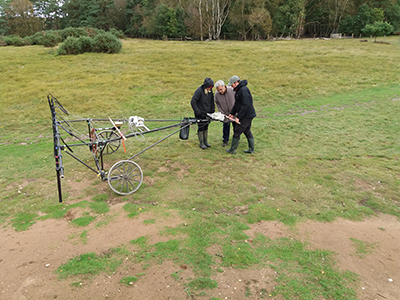 3 people standing with cart