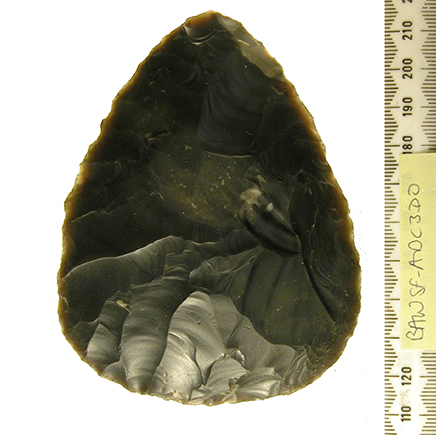 a finely flaked handaxe made on flake. It is made of dark flint and teardrop shaped