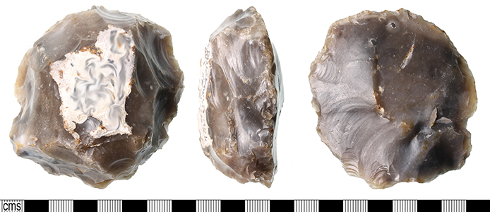 a heavily flaked flint levallois core, roughly circular with flakes taken from edges.