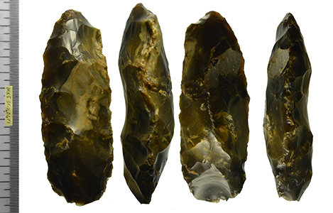 image shows multiple sides of a flaked flint axehead