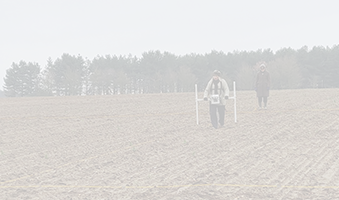 person holding magnetometer in field