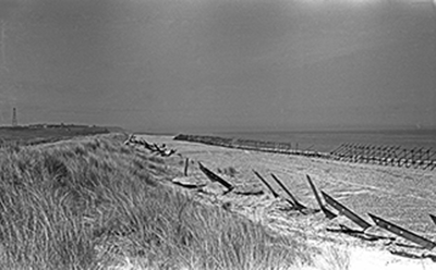 wartime photo of scaffolding and ‘Dragon’s Teeth’ on beach